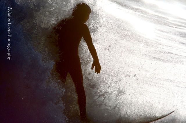 Every now and then the surf would carry someone to where the rising sun would backlight the wave